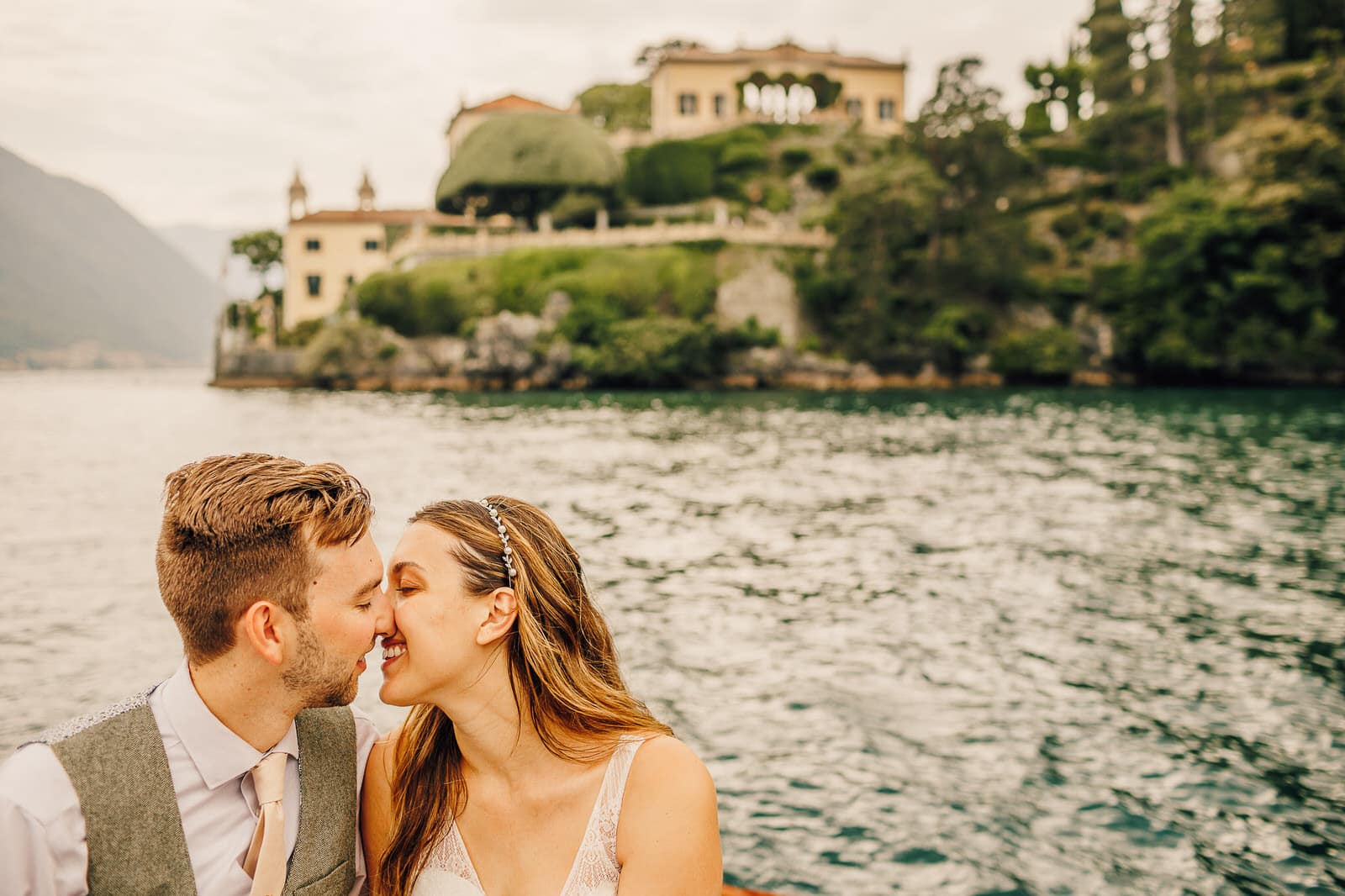 Bride and groom kiss on a boat on Lake Como