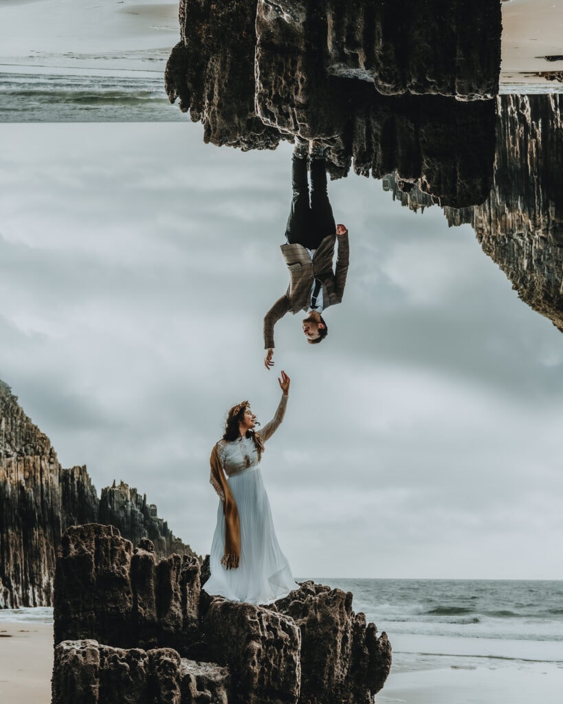 Double exposure photograph of Bride and groom standing on rocks on a beach in Wales for their elopement
