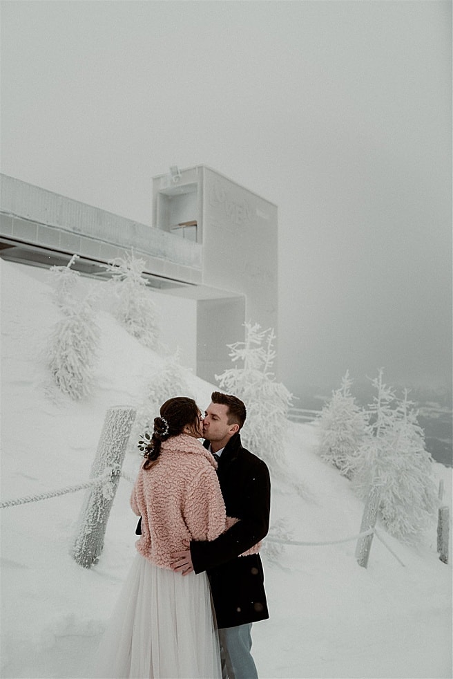 bride and groom kissing in front of the Lumen museum