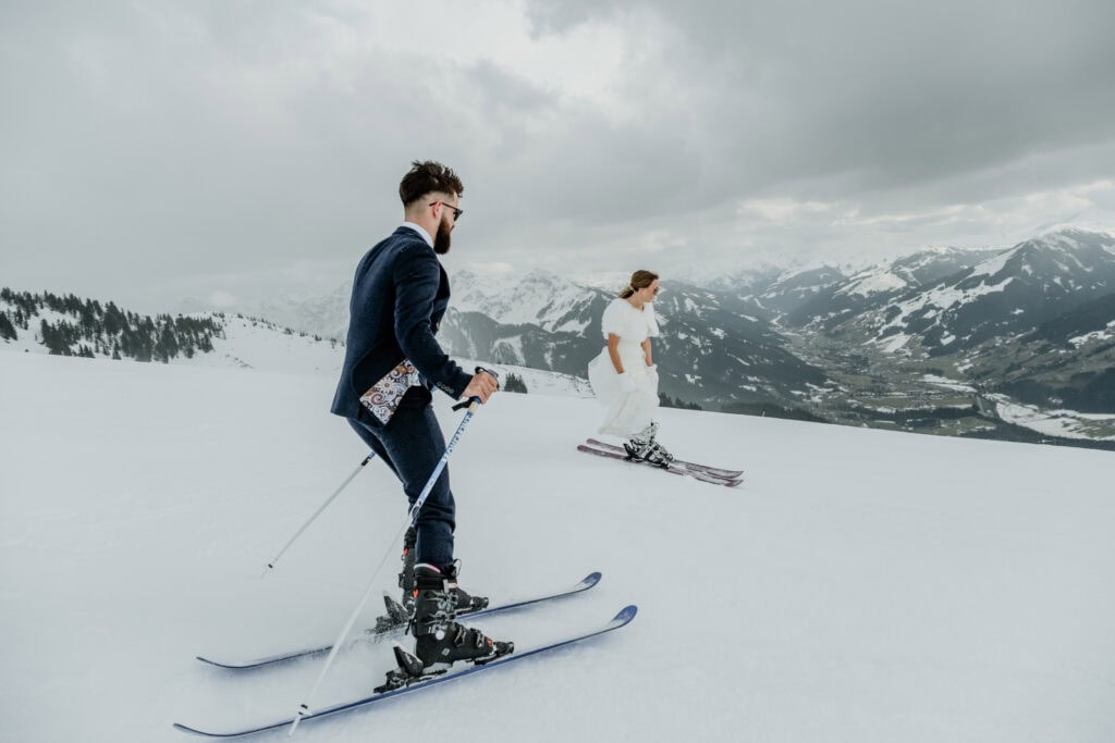 Skiing bride and groom on a snowy mountain in Kitzbühel Austria