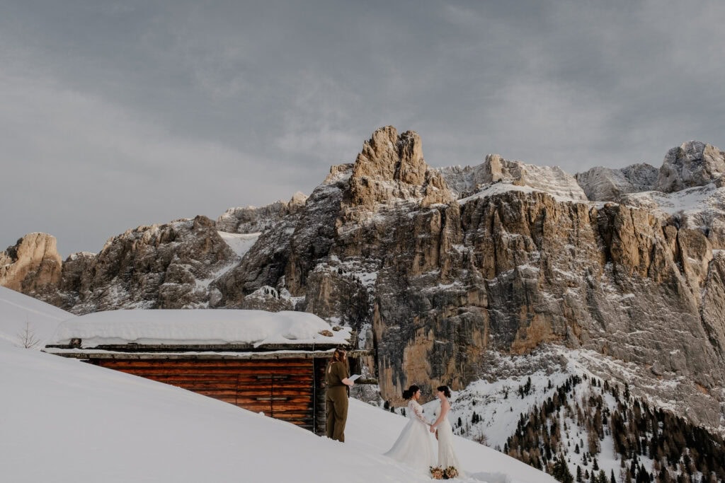 Two brides get married in the snow outside a mountain hut in Val Gardena in the Dolomites.