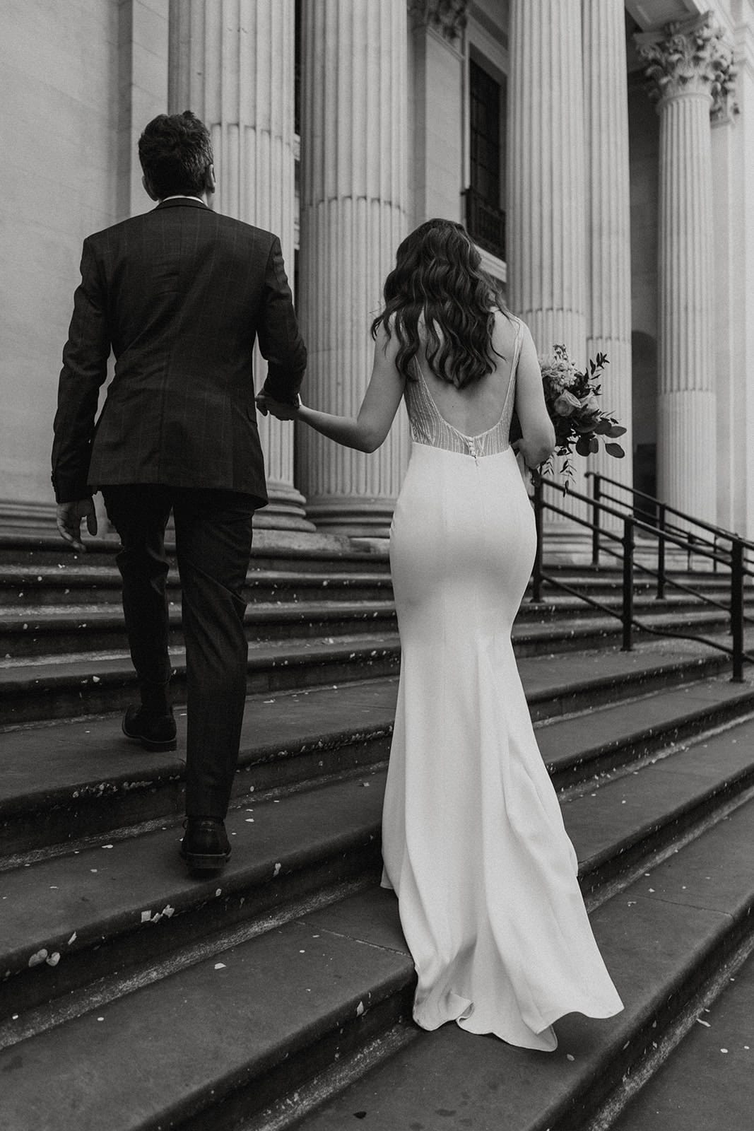 Bride and groom walking up the steps of Old Marylebone Town Hall